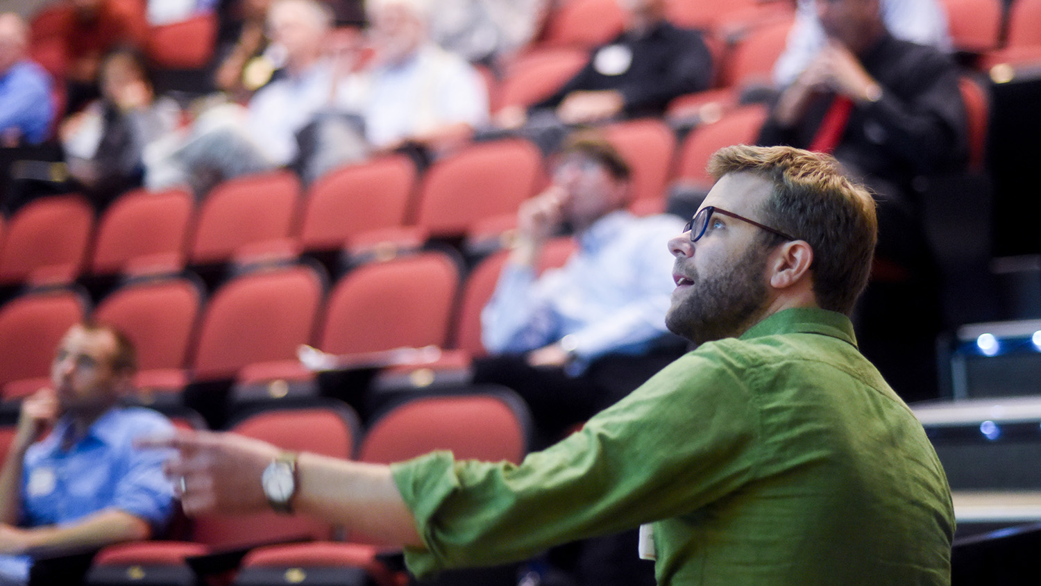 A man speaks in front of a lecture hall
